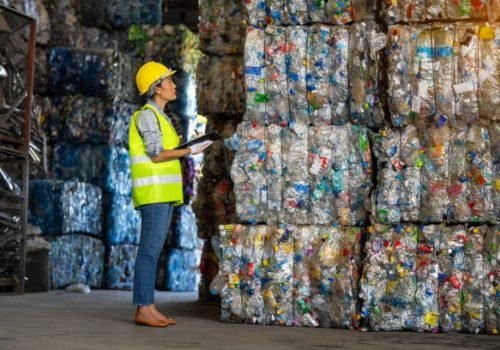 Female worker checks the stock and controls the separation of recyclable waste of the plastic waste recycling plant. And other types of waste, the concept of recycling.